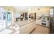 Spacious kitchen with granite island, white cabinets, and breakfast area with sliding glass doors at 1017 Jamaica Way, Tarpon Springs, FL 34689