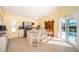Sunlit kitchen featuring tile floors, central island, and barstool seating overlooking the pool area at 1017 Jamaica Way, Tarpon Springs, FL 34689