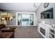 Living room boasts a fireplace, large TV, and view of the pool through sliding glass doors at 1017 Jamaica Way, Tarpon Springs, FL 34689