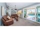 Open-concept living room with brown leather seating and sliding glass doors leading to the outdoor pool area at 1017 Jamaica Way, Tarpon Springs, FL 34689