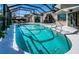 Expansive pool within a screened enclosure, featuring an outdoor seating area and direct access to the home at 1017 Jamaica Way, Tarpon Springs, FL 34689