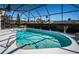 Inviting pool with a screened enclosure, lush landscaping, and comfortable seating area at 1017 Jamaica Way, Tarpon Springs, FL 34689