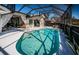 A screened-in pool area with a sparkling pool, lounge chairs, and access to both the interior and backyard at 1017 Jamaica Way, Tarpon Springs, FL 34689