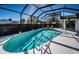 Serene pool area within a screened enclosure, enhanced by lush greenery and outdoor seating at 1017 Jamaica Way, Tarpon Springs, FL 34689