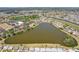 Birds-eye view of neighborhood amenities including a large pond, community buildings and residential houses at 1021 Augusta Dr, Sun City Center, FL 33573