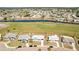 A landscape view of the property, that is in a golf community and has a white exterior with black trim at 1021 Augusta Dr, Sun City Center, FL 33573