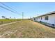 A view of the spacious backyard with grass and a chain link fence, with the property in the background at 1021 Augusta Dr, Sun City Center, FL 33573