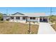 Well-maintained single-story home boasting a covered driveway, white exterior, black trim, and an inviting front yard at 1021 Augusta Dr, Sun City Center, FL 33573