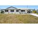 One story house with white exterior and black trim, landscaped yard, covered parking at 1021 Augusta Dr, Sun City Center, FL 33573