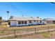 Charming white single-story home featuring a well-maintained lawn, black chain-link fence, and a newer gray roof at 1021 Augusta Dr, Sun City Center, FL 33573