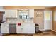 Bright kitchen with white cabinetry, stone countertops, stainless steel appliances, and wood-look flooring at 1021 Augusta Dr, Sun City Center, FL 33573
