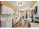 Modern kitchen featuring stainless steel appliances, white cabinetry and stone countertops with a laundry room view at 1021 Augusta Dr, Sun City Center, FL 33573