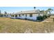 Home features a spacious backyard, white exterior, gray roof, and black fencing at 1021 Augusta Dr, Sun City Center, FL 33573