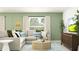 Cozy living room featuring sage green walls, a comfortable grey sectional, and a round coffee table at 10301 Gentle Rain Dr, Land O Lakes, FL 34638