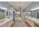 Bathroom with double vanities, a soaking tub, and a stained-glass window for added charm at 1123 Signature Dr, Sun City Center, FL 33573