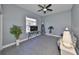 Well-lit bedroom featuring a ceiling fan, a large window, and neutral gray walls at 1123 Signature Dr, Sun City Center, FL 33573