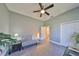 Bedroom featuring gray walls, a ceiling fan, and a comfortable seating area with natural light at 1123 Signature Dr, Sun City Center, FL 33573