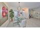 Bright dining room with modern lighting fixture, glass table, and views to the living area at 1123 Signature Dr, Sun City Center, FL 33573