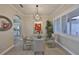 Elegant dining room with modern chandelier, glass table and chairs, and view to kitchen at 1123 Signature Dr, Sun City Center, FL 33573