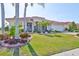 Charming single-story home with a red tile roof, lush landscaping, and a well-manicured lawn at 1123 Signature Dr, Sun City Center, FL 33573
