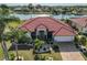 Beautiful single-story home features a red tile roof, lush landscaping, and a paver driveway at 1123 Signature Dr, Sun City Center, FL 33573
