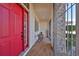 Charming front porch features brick flooring, a red front door, and security gate at 1123 Signature Dr, Sun City Center, FL 33573