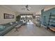 Bright and airy living room featuring tile floors, a large sofa, and sliding glass doors to the lanai at 1123 Signature Dr, Sun City Center, FL 33573
