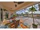 Spacious screened-in lanai with brick flooring, ceiling fans, dining set and seating, overlooking the lake at 1123 Signature Dr, Sun City Center, FL 33573