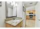 Modern bathroom with a granite countertop, sink, and a view into the bright kitchen at 11605 Gulf Blvd # 404, Treasure Island, FL 33706