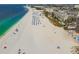 Beautiful beachfront view with white sand, turquoise water, beach umbrellas, and tall buildings at 11605 Gulf Blvd # 404, Treasure Island, FL 33706