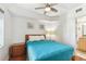 Bedroom with wooden furniture, a ceiling fan, and an adjacent bathroom at 11605 Gulf Blvd # 404, Treasure Island, FL 33706