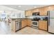 Well-lit kitchen featuring stainless steel appliances, light wood cabinets, and tiled floors at 11605 Gulf Blvd # 404, Treasure Island, FL 33706