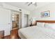 Bright bedroom featuring hardwood floors, a ceiling fan, an adjacent bathroom, and a closet at 11605 Gulf Blvd # 404, Treasure Island, FL 33706