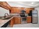 Kitchen featuring stainless steel appliances, granite countertops, and wood cabinets at 11650 Capri S Cir # 203, Treasure Island, FL 33706