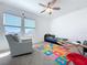 Bright bedroom featuring a ceiling fan, carpet flooring, and natural light from the window at 11828 Cara Field Ave, Riverview, FL 33579