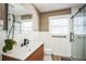 Modern bathroom features wood-look vanity, sleek black fixtures, shower with glass door, and window at 1235 14Th N St, St Petersburg, FL 33705