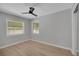 A bedroom featuring hardwood floors, a ceiling fan, and natural light from the windows at 1235 14Th N St, St Petersburg, FL 33705