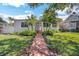 Charming home featuring a brick walkway, well-manicured lawn, and inviting landscaping at 1235 14Th N St, St Petersburg, FL 33705