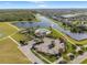 An aerial view of a community pool, clubhouse, parking area, and lakes surrounded by homes on a sunny day at 13538 Willow Bluestar Loop, Riverview, FL 33579