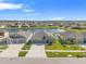 Aerial view of a home with a three car garage, manicured lawn, and peaceful pond in a Gathering-friendly neighborhood at 13538 Willow Bluestar Loop, Riverview, FL 33579