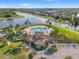 Aerial view of a beautiful community pool, clubhouse, and pond surrounded by lush landscaping and charming homes at 13538 Willow Bluestar Loop, Riverview, FL 33579