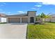 Beautiful single-Gathering home with a two-car garage, lush green lawn, and attractive landscaping at 13538 Willow Bluestar Loop, Riverview, FL 33579