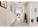 Bright hallway with tile flooring, neutral walls, and decorative art pieces leading into the home's living spaces at 13538 Willow Bluestar Loop, Riverview, FL 33579