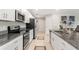 Modern kitchen featuring granite countertops, stainless steel appliances, and white cabinetry for a sleek design at 13538 Willow Bluestar Loop, Riverview, FL 33579