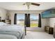 Comfortable bedroom featuring a large window overlooking a fenced yard, offering natural light and privacy at 13538 Willow Bluestar Loop, Riverview, FL 33579