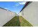 Clean side yard featuring well-maintained grass and a white picket fence, providing privacy at 13538 Willow Bluestar Loop, Riverview, FL 33579