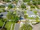 Aerial view showcases backyard oasis with screened pool, manicured lawn, and mature trees enhancing privacy in a residential neighborhood at 14916 Rocky Ledge Dr, Tampa, FL 33625