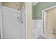 Bright bathroom with white tiled shower and separate tub with olive accent wall at 14916 Rocky Ledge Dr, Tampa, FL 33625