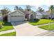 Lovely one-story home featuring a two-car garage, arched entryway, well-kept lawn, and a sunny driveway at 14916 Rocky Ledge Dr, Tampa, FL 33625