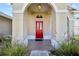 Inviting front entrance showcasing a vibrant red door, brick landing, and arched doorway at 14916 Rocky Ledge Dr, Tampa, FL 33625